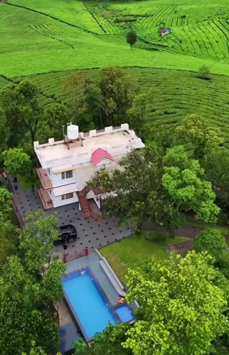 Aerial view of GREENSHORE Villa's pool and property surrounded by tea plantations